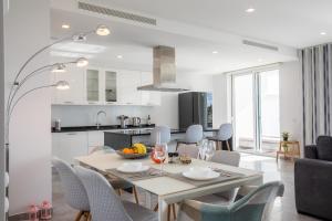 Casa Chloe Luxury Ocean View Apartment في لاغوس: مطبخ وغرفة طعام مع طاولة وكراسي