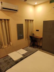 1 dormitorio con cama, mesa y escritorio en Sree Nivas Homestay, en Trivandrum