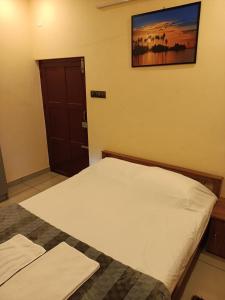 1 dormitorio con 2 camas y una foto en la pared en Sree Nivas Homestay en Thiruvananthapuram