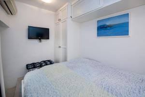 a bedroom with a bed and a tv on the wall at Apartment Art in Rovinj