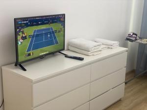 a tv on top of a dresser with a video game on it at Комфортная квартира на ЭКСПО/ Comfortable flat on EXPO in Taldykolʼ