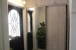 a mirror in a hallway with a window and a plant at Deluxe guest house in Kvariati