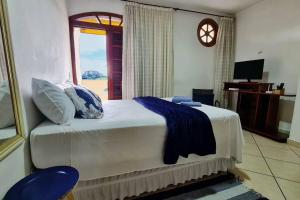 a bedroom with a large bed with a window at Studio com Varanda para Serra in Jundiaí