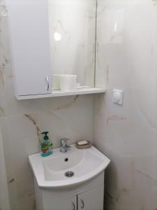 a white bathroom with a sink and a mirror at Trojan i Slobodanka in Ribarska Banja