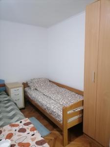 a small bedroom with a bed and a cabinet at Trojan i Slobodanka in Ribarska Banja