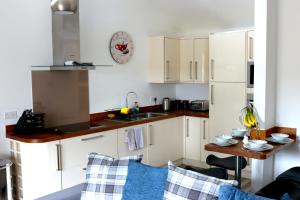 a kitchen with white cabinets and a sink and a table at Ferndown Holiday Let in Ferndown