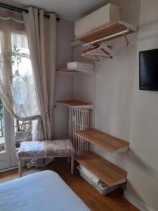 1 dormitorio con estanterías de madera, 1 cama y ventana en Chambre d'hôtes avec garage au bord de mer, en Toulon