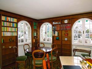 a dining room with a table and chairs and windows at Villa Pinetina in Gargnano