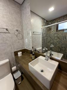 a bathroom with a sink and a toilet and a mirror at Pousada Luar da Ilha in Fernando de Noronha