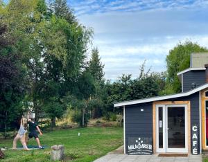 two people playing frisbee in front of a shed at Hostel del Valle in Recinto