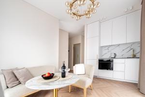 uma sala de estar com uma mesa e um sofá em Golden Apartment Paupys em Vilnius