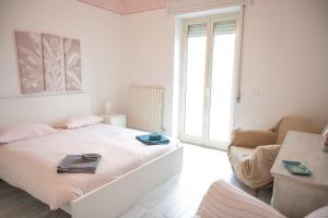 Habitación blanca con cama y sofá en Casa Annalisa - Fronte Mare en Pescara
