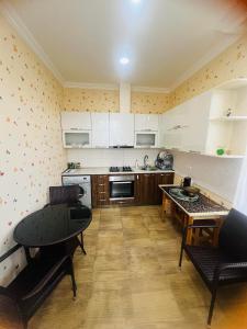 a kitchen with white cabinets and a table at guest house TMT in Sighnaghi