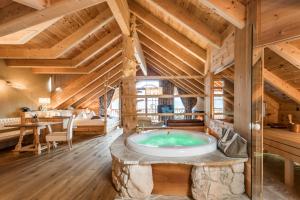 eine Whirlpool-Badewanne in einem Zimmer mit Holzdecken in der Unterkunft Naturhotel Lüsnerhof in Lüsen