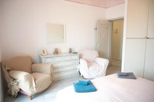 um quarto com uma cama, 2 cadeiras e uma cómoda em Casa Annalisa - Fronte Mare em Pescara
