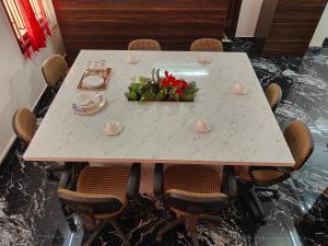 a dining room table with a centerpiece of flowers on it at Sunshine Villa & Homestay in Tiruchirappalli
