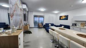 a large living room with a blue couch and a kitchen at Haifa night's in Haifa