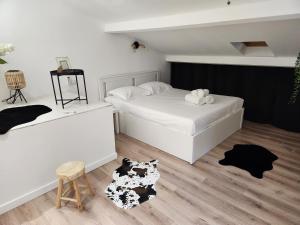 - une chambre blanche avec 2 lits et un tabouret dans l'établissement Lou Ronsard, à Bouc-Bel-Air