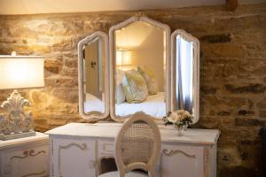 a bedroom with a bed with a large mirror at The Footmans Cottage in Longwitton