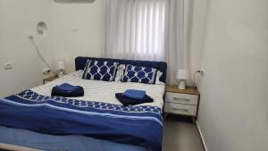 a bedroom with a bed with blue pillows on it at Haifa night's in Haifa