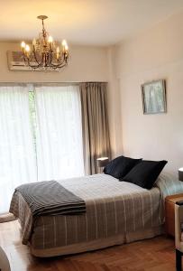une chambre avec un grand lit et un lustre dans l'établissement French I Recoleta, à Buenos Aires