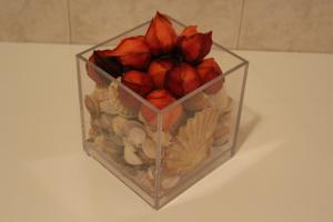 a glass container filled with seashells and flowers on a table at House4U Vila Nova in Vila Nova de Gaia