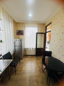 a kitchen with a table and chairs and a refrigerator at guest house TMT in Sighnaghi