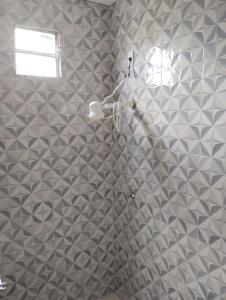a bathroom with a shower with gray and white tiles at Pousada Vida Nós Lencois in Barreirinhas