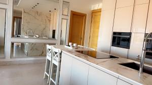 uma cozinha com armários brancos e uma bancada em Superbe appartement de luxe a l'hivernage marrakech em Marraquexe