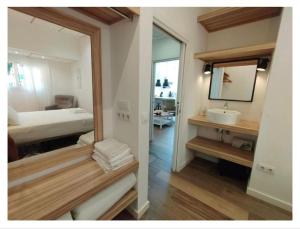 a bathroom with a mirror and a bed and a sink at apartamento triana Arellano in Seville