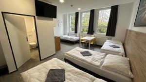 a room with two beds and a table and windows at Hotel Hangar in Mošnov