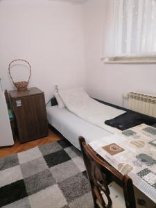 ein Schlafzimmer mit einem Bett, einem Tisch und einem Stuhl in der Unterkunft Trojan i Slobodanka in Ribarska Banja