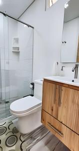 een badkamer met een toilet, een wastafel en een spiegel bij 203 Norte cali - The view in Cali