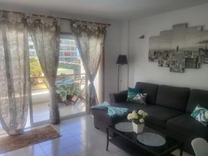 sala de estar con sofá y ventana grande en Apartamento Sol & Arena, en Puerto de Santiago