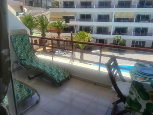 balcón con sillas y vistas a un edificio en Apartamento Sol & Arena, en Puerto de Santiago
