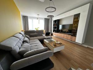 a living room with a large couch and a television at 2 BR Sky Luxury Home and free parking. in Sofia