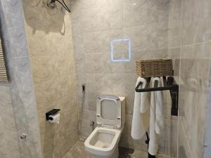 a bathroom with a toilet and towels in it at Urban View Lodge - Apt.5 Room 1 in Abuja