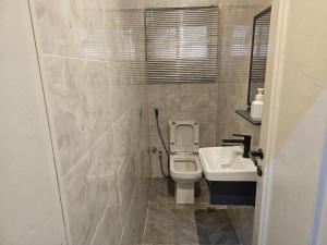 a bathroom with a toilet and a sink at Urban View Lodge - Apt.5 Room 1 in Abuja