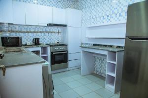 阿布賈的住宿－Urban View Lodge - Apt.5 Room 1，厨房配有白色橱柜和炉灶烤箱。