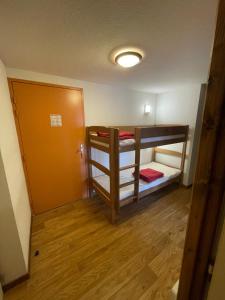 a room with two bunk beds and a door at Droseras A02 - Chamrousse 1700 - Les Villages du Bachat in Chamrousse