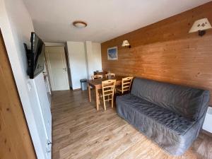 a living room with a couch and a table at Droseras A02 - Chamrousse 1700 - Les Villages du Bachat in Chamrousse