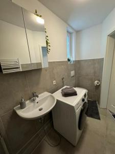 ein Badezimmer mit einem Waschbecken, einem WC und einem Spiegel in der Unterkunft Ferienwohnung In Bremerhaven in Bremerhaven