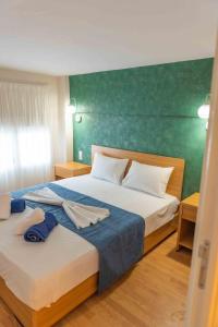 una camera da letto con due letti e una parete verde di INFINITY SEASIDE APARTMENTS a Nea Kalikratia