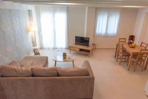 a living room with a couch and a television at INFINITY SEASIDE APARTMENTS in Nea Kallikrateia