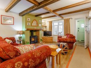 ein Wohnzimmer mit roten Möbeln und einem Kamin in der Unterkunft 3 Bed in Ventnor 89810 in Ventnor