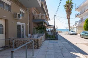 un edificio su una strada con l'oceano sullo sfondo di INFINITY SEASIDE APARTMENTS a Nea Kalikratia