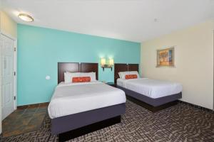 two beds in a hotel room with blue walls at Monte Carlo Boardwalk / Oceanfront Ocean City in Ocean City