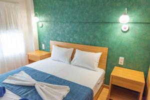 una camera da letto con un letto e una parete verde di INFINITY SEASIDE APARTMENTS a Nea Kalikratia