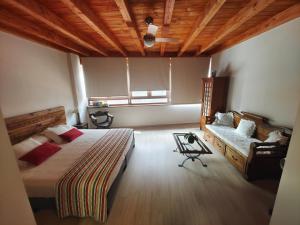 ein Schlafzimmer mit einem Bett und einem Sofa darin in der Unterkunft La Posada de Bayuela in Castillo de Bayuela