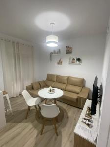uma sala de estar com um sofá e uma mesa em Apartamento Vitelio em Carmona